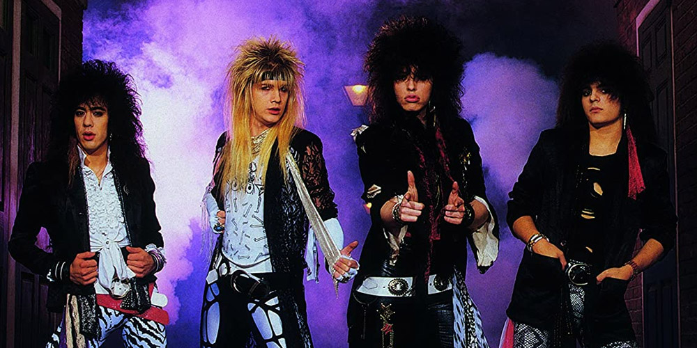 four members from the hair band group cinderella posing with purple fog rising behind them