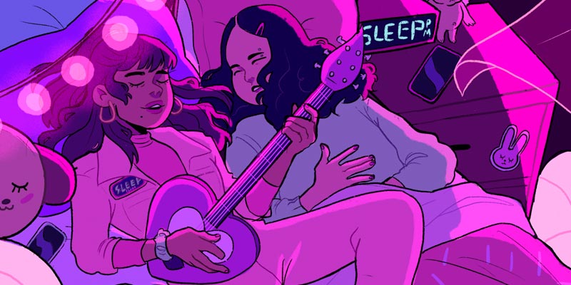 two girls lying in bed and one is playing a heart shaped guitar