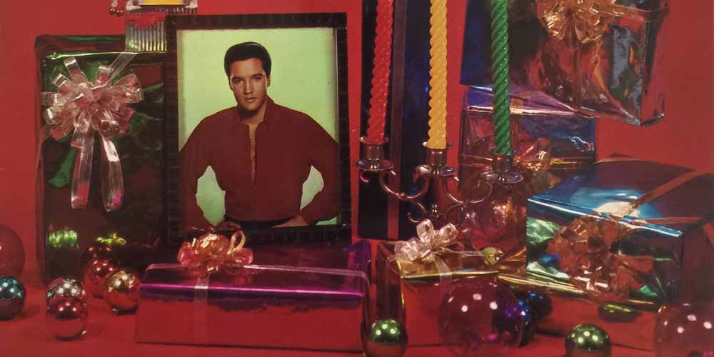 a picture of elvis presley surrounded by chirstmas gifts